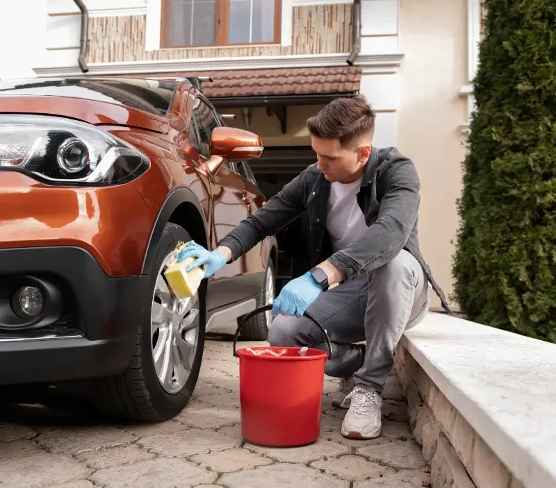 Lavage auto à domicile Le Val d'Hazey : professionnel intervenant sur un véhicule